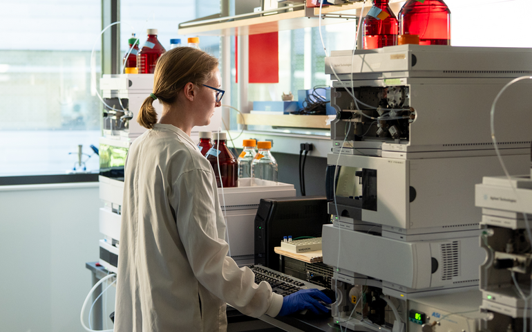 A person stands at machines on a counter.