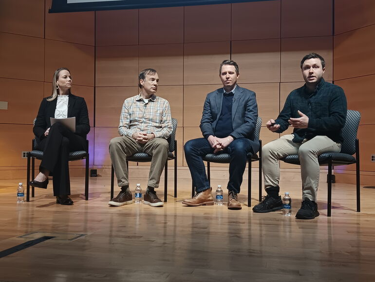 four people on stage for a panel discusssion