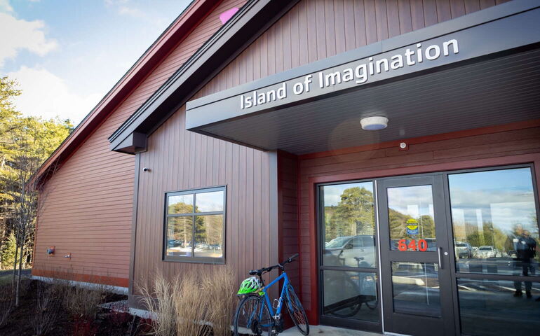 An exterior view of a building shows its entryway with a bike.