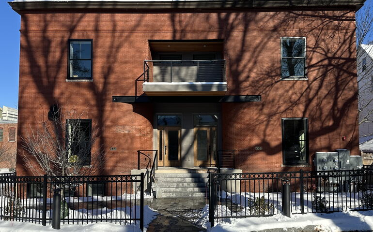 An exterior view of a building with a fence in front of it.