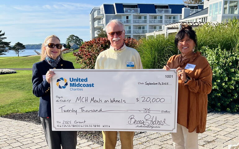 three people holding a huge check