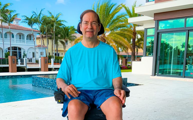 Jonathan Ayers in a wheelchair in front of a swimming pool in Florida
