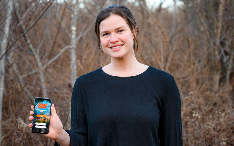 Person outdoors holding up a smart phone 