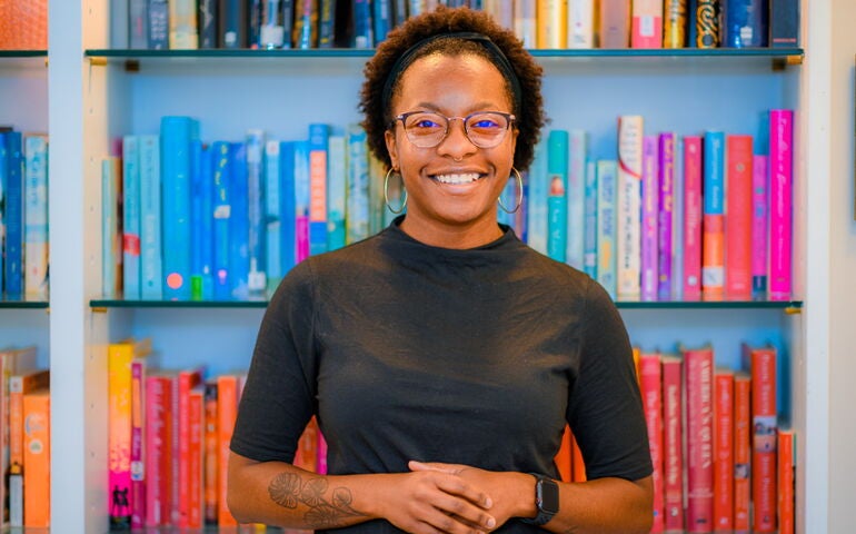 Person standing in from of books on shelves 