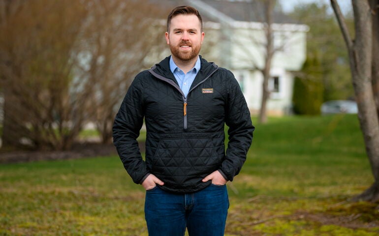 Ryan Fecteau standing outside with a duplex house in the background, in Biddeford
