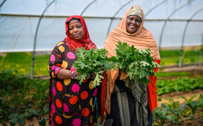 Women farmers holding crops 
