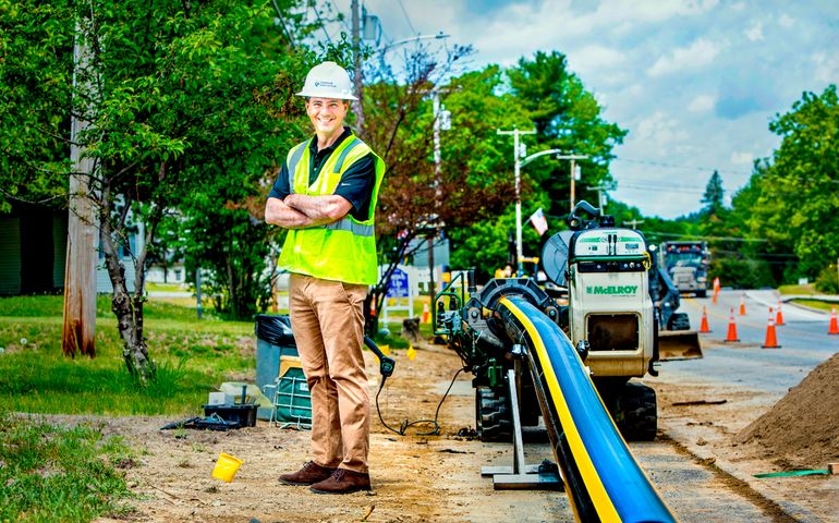 Kurt Adams wearing a hard hat by gas equipment on a job site 