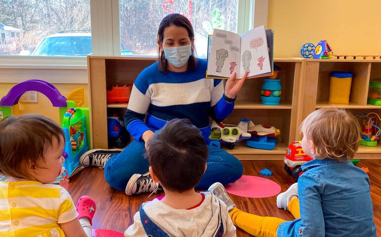 woman reading a book to little ones in a child care center 