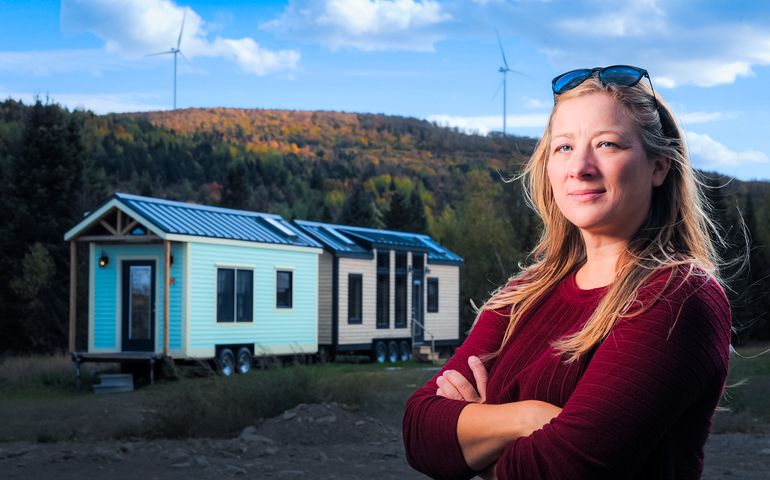 Corinne Watson in foreground, tiny home in background 