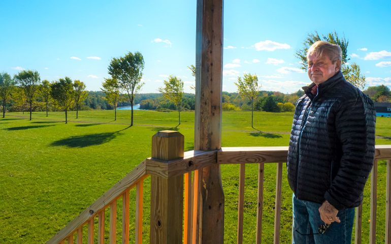 man standing outside overlooking green space