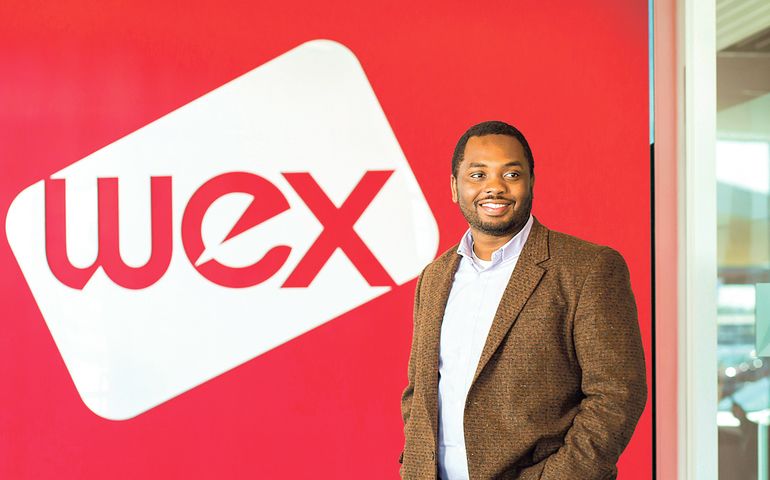 Gimbala Sankare in front of a red wall with WEX logo on it 