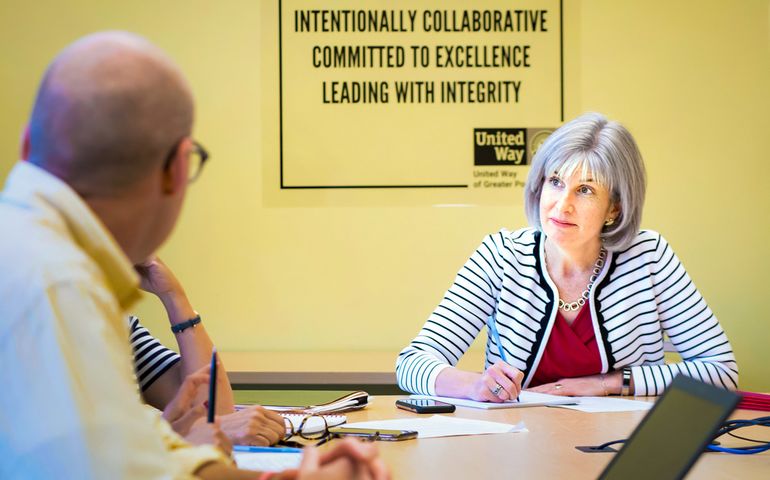 Liz Cotter Schlax in United Way office talking to someone in a conference room