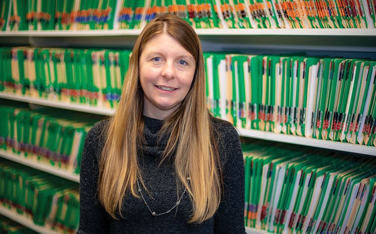 Tabitha Swanson in front of file folders on shelves