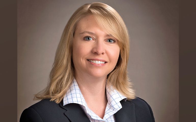 A head and shoulders photo of a smiling blond white woman