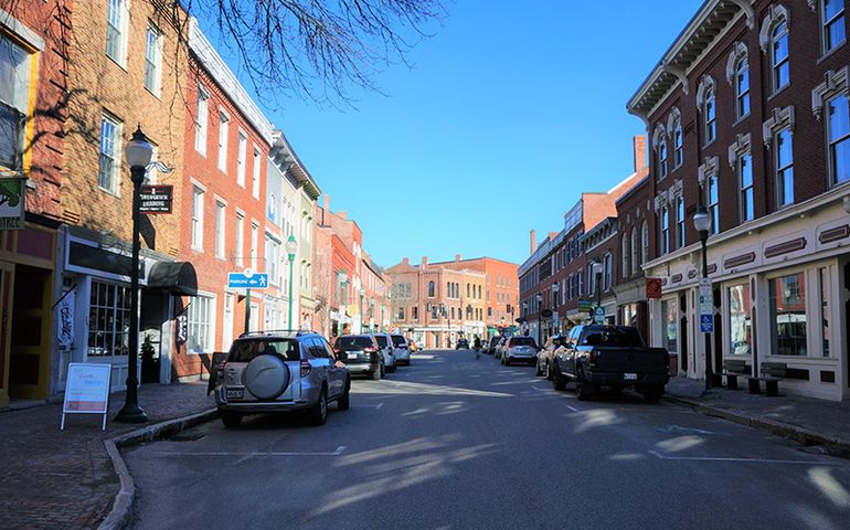 a city street with two and three story brick buildings from the 1800s