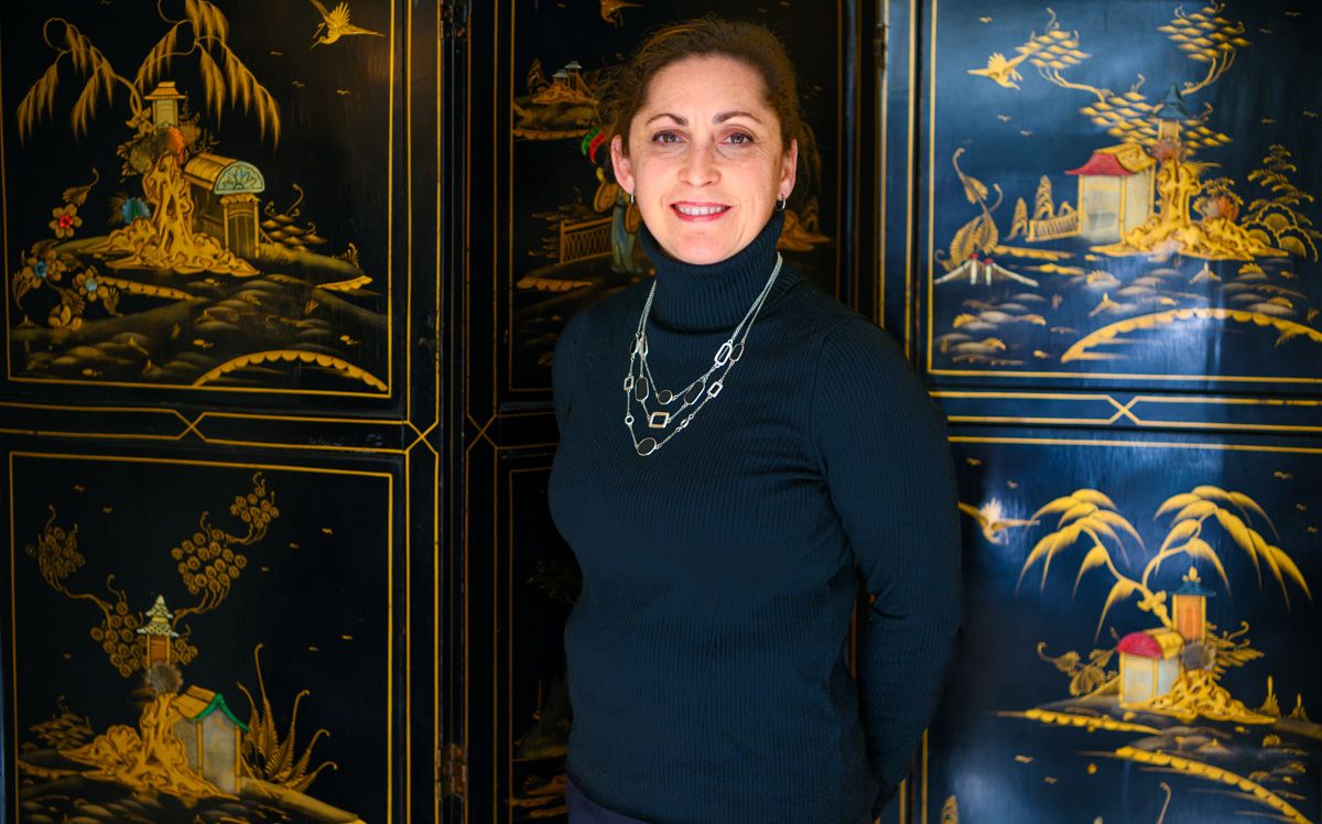 Dr. Sasha Rose standing in front of a Chinese-motif decor at her practice.