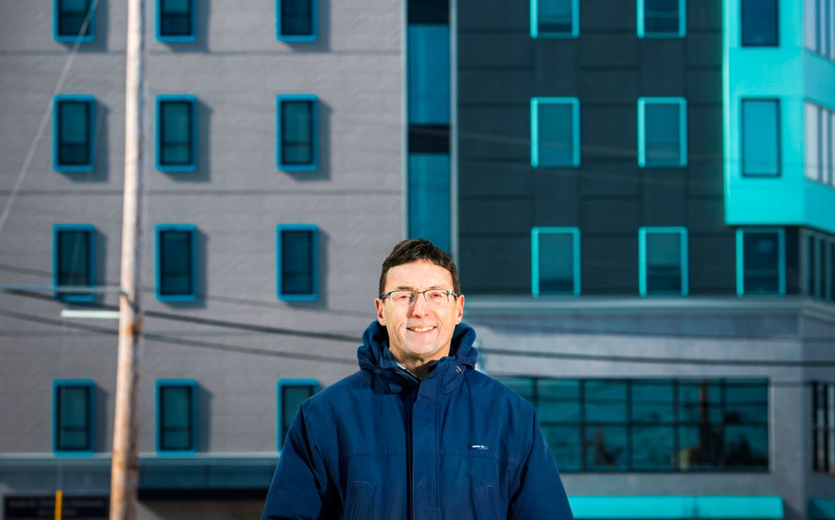 man standing in front of apartment building