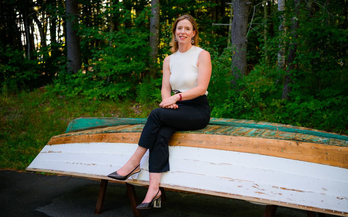 Melissa LaCasse seated, on a wooden boat 